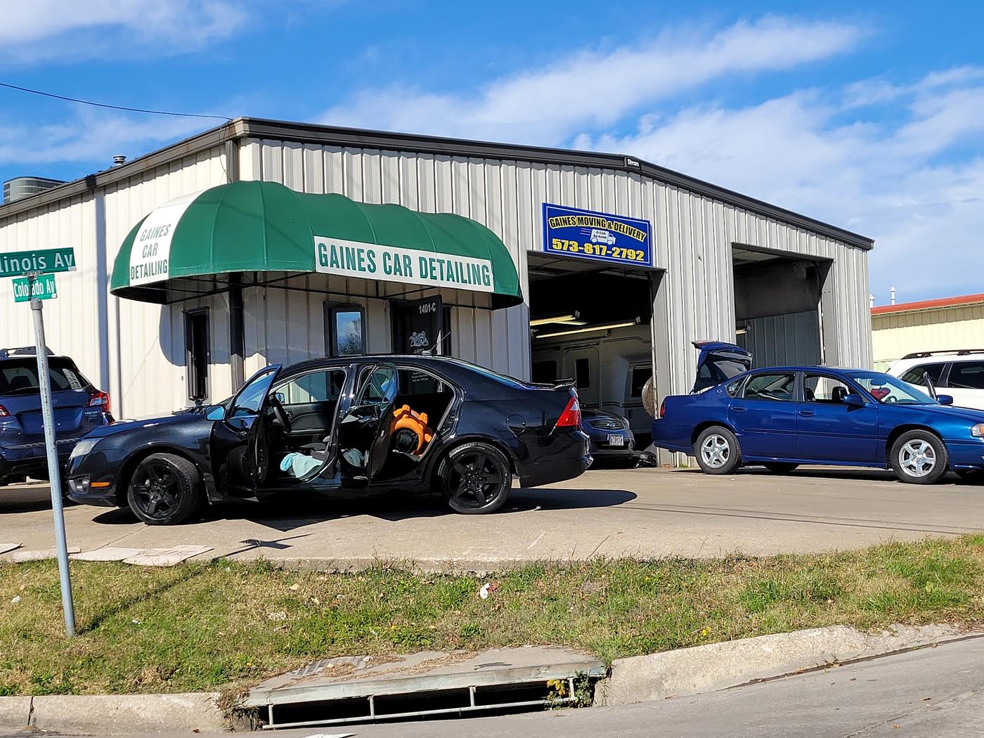 The Gaines shopfront on the corner of Illinois and Colorado: a green Gaines Car Detailing awning, a blue Gaines Moving and Delivery sign, and two open work bays